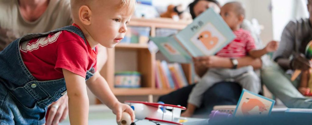 Toddlers play in quality child care environment as parents watch
